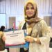Kepala Subkoor Pengelolaan Media Komunikasi Publik, Suryani, saat menerima penghargaan pada saat penyelenggaraan Konferensi Tingkat Tinggi (KTT) Ke-42 ASEAN Tahun 2023.
