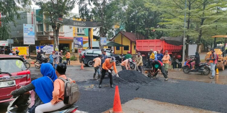 Para pekerja dari Dinas Bina Marga dan Sumber Daya Air melakukan perbaikan jalan. (Foto : Ikhsan).