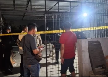 Petugas memasang garis polisi di TKP. (foto/net)