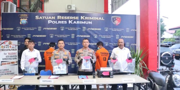Polisi mengamankan dua orang pengedar uang palsu. (foto/net)