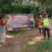Anggota Polsek Belitang III memasang spanduk himbauan karhutla. (Foto/Yesi)