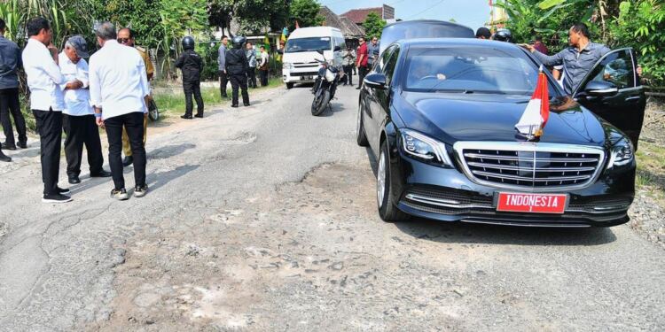 Presiden Jokowi turun dari mobil dan langsung meninjau jalan yang rusak di Lampung. (foto/net)