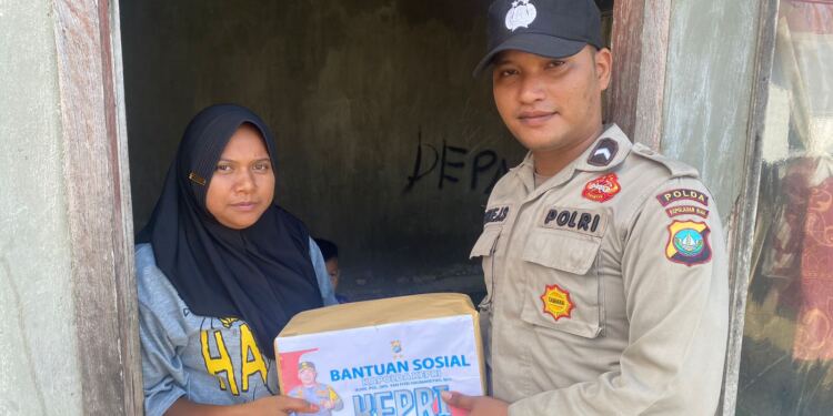Anggota polsek Daik Lingga memberikan bantuan kepada warga kelurahan Daik. (foto/doc)