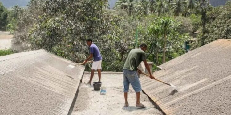 Warga mulai membersihkan material vulkanis di atas rumah (foto/ist)