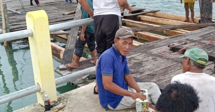 Sejumlah warga yang tengah memperbaiki salah satu bagian Pelabuhan Mepar yang rusak (foto/Wartawan Biro Kab. Lingga)