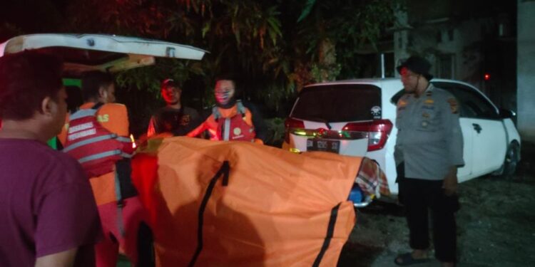 Petugas saat mengevakuasi jasad korban. (foto/Media Center Riau)