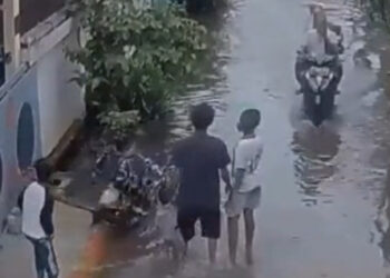 Tangkapan layar dari CCTV saat pelaku melempar anaknya ke genangan banjir. (foto/ist)