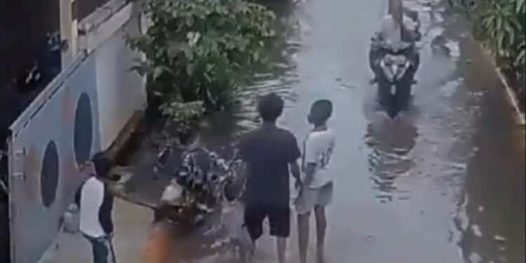 Tangkapan layar dari CCTV saat pelaku melempar anaknya ke genangan banjir. (foto/ist)