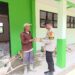 Kanit Binmas Aiptu Eko Budi Santo membagikan nasi kotak kepada warga kuli bangunan yang berada di Desa Kelirejo Kecamatan Belitang II, Jum'at, 31 Januari 2025. (foto/Yesi)