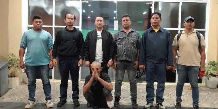 Pelaku saat diamankan petugas, nampak kaki kiri Andi ditembak. (foto/dok)