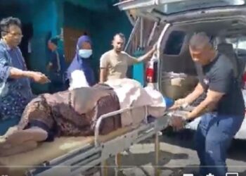 Salah satu ibu-ibu korban keracunan makanan hajatan yang dibawa ke ambulans. (foto/ist)