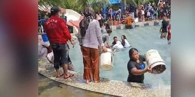 Warga membantu evakuasi korban dengan membuang air memakai ember. (foto/ist)