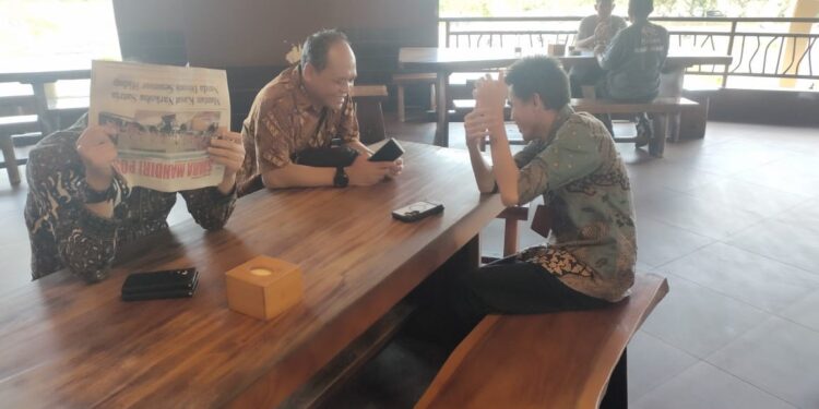 Oknum Kepala Dinas Perkimtan Kota Batam Eryudhi Apriadi menutup wajah dengan koran. (Foto/Sam Guci).