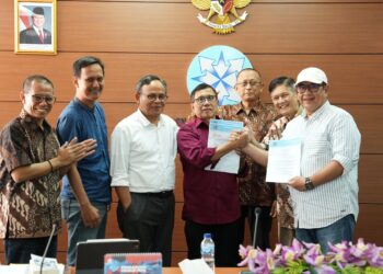 Ketua Umum PWI Kongres Luar Biasa, Zulmansyah Sekedang (paling kanan), berjabat tangan dengan Ketua Umum PWI Kongres Bandung, Hendry Ch Bangun. (Foto/pwi Kepri).
