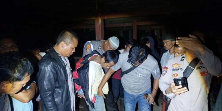 Polisi mengamankan pelaku yang tebas ayahnya di Dusun Lombang 1, Desa Poda-Poda, Kecamatan Tutar, Kabupaten Polman, Sulbar, pada Jumat (19/9/2025). (Foto/Doc)