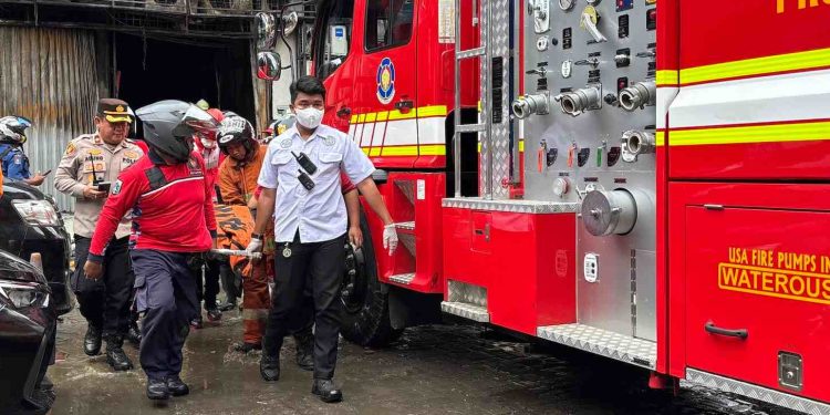 Petugas mengevakuasi salah satu jasad korban tewas kebakaran toko drone di Kemayoran. (Foto/Doc)