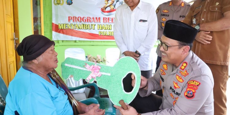 Kapolres Langkat Serahkan Kunci Rumah Hasil Bedah Rumah kepada Ibu Ginah. (Foto/Jhon).
