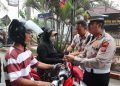 Sejumlah Personil Polres Langkat Bagikan Bendera Merah Putih Kepada Masyarakat. (Foto/Jhon).