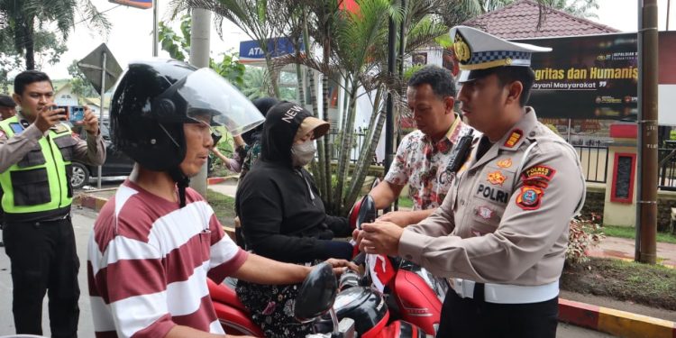 Sejumlah Personil Polres Langkat Bagikan Bendera Merah Putih Kepada Masyarakat. (Foto/Jhon).