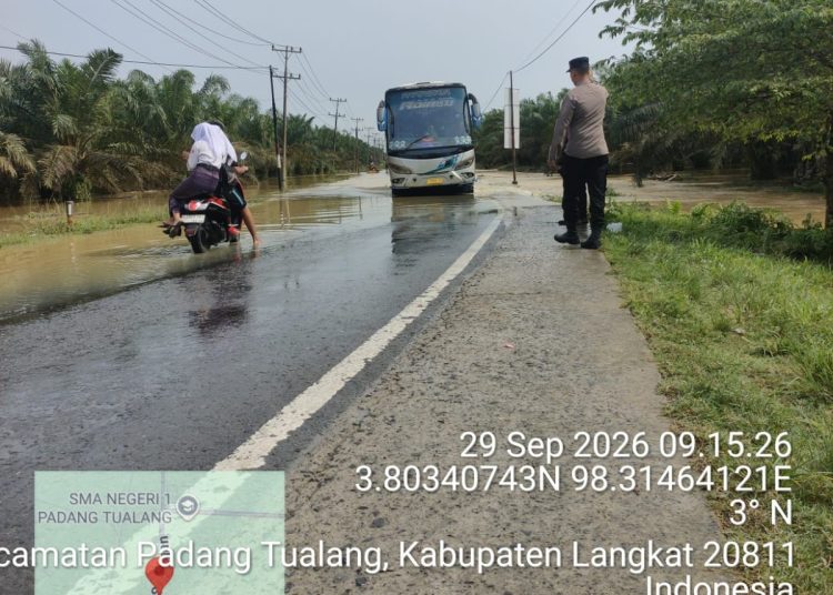 Banjir Rendam Jalan Sumor bor-Tanjung Selamat, Polsek Padang Tualang Sigap Atur Lalu Lintas. (Foto/Jhon).